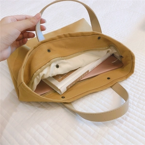Top view of open yellow canvas tote bag showing interior lining and large capacity storage