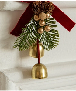 Detail of gold Christmas bells with red velvet bow, pine cones and green needles