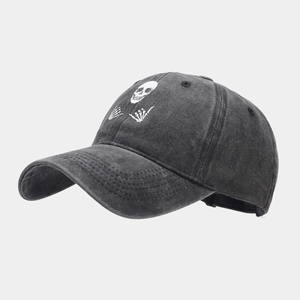 Close-up of rock style skull and shaka skeleton hand embroidery on cotton baseball cap