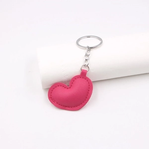 Detailed close-up of a pink heart-shaped PU leather keychain with silver metal ring