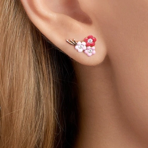Macro view of multi-color enamel flower ear climbers on ear with sparkling rhinestones