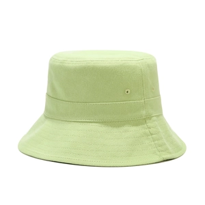 Detail of light green cotton bucket hat showing metal eyelets and reinforced brim stitching