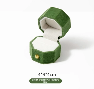 Macro shot of 4x4x4cm green velvet octagonal ring box with soft white interior slot