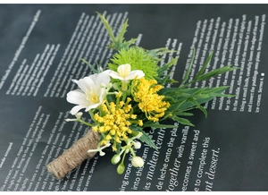 Detail of wedding boutonniere featuring white flowers, greenery, and burlap twine wrap