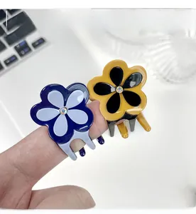 Détail de petites pinces à cheveux fleur avec strass montrant la taille réelle