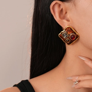 Macro close-up of vintage resin enamel stud earring with inlaid colorful rhinestones