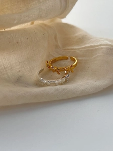 Close-up of gold and silver S925 sterling silver bow rings on beige linen fabric