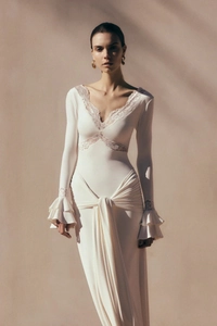 Detail of V-neck lace trim and ruffled bell sleeves on cream long sleeve dress