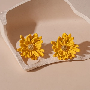 Detailed macro shot of yellow flower studs with golden center on minimalist tray