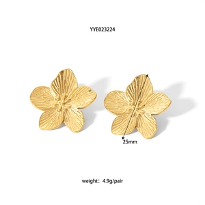 Macro shot of 25mm gold floral stud earrings with fine brushed texture and weight details