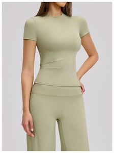 Close-up of quick-dry yoga t-shirt fabric and seams in pale bean green sport suit