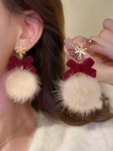 Detail of Christmas snowflake stud earrings with velvet bow and white pompom pendant