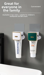 Wall-mounted toothpaste squeezer shown in green and white colors with gold accents
