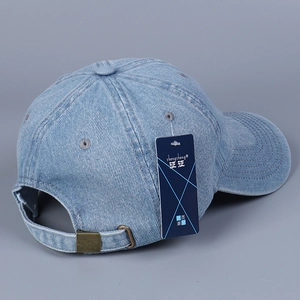 Detail of adjustable metal buckle on light blue denim baseball cap with stitching
