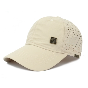 Detail of beige quick-dry baseball cap with laser-cut breathability holes and metal badge
