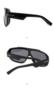 Detail view of oversized sunglasses featuring sleek black frame and iconic T-shaped hinges