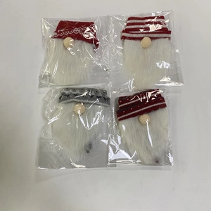 Detailed view of 4-piece knit Christmas gnome wine bottle toppers in clear packaging