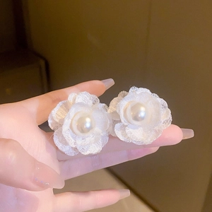 Detail shot of white mesh floral earrings featuring elegant lace petals and center pearls