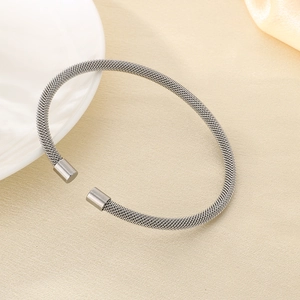 Detail view of woven mesh texture on silver stainless steel open cable bracelet