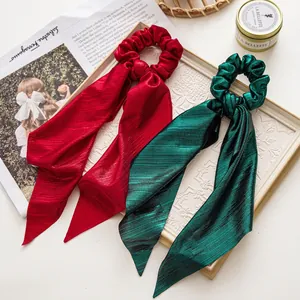 Christmas bow scrunchies in red and green shimmering fabric with long hanging ribbons