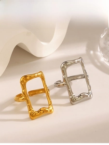 Detailed macro view of gold and silver rectangular hollow rings with liquid metal texture