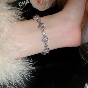 Detailed view of luxury silver bracelet with pink zircon heart and shimmering crystals