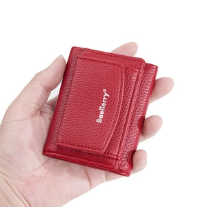 Nahaufnahme der roten Mini-Geldbörse aus Leder mit Litschistruktur und Druckknopf