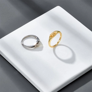 Artistic display of gold and silver dome croissant rings on geometric pedestals