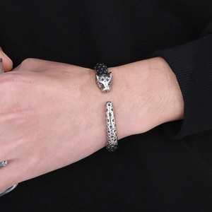 Detailed view of punk-style leopard head open bangle in antique silver finish