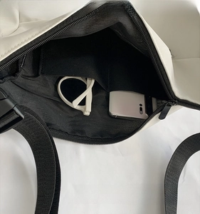 Detailed interior view of white canvas messenger bag with dual pockets and zipper