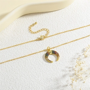 Macro shot of gold horn pendant with multicolored micro-pave zircons and delicate chain