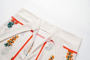 Détail du tissu à fleurs orange et rayures verticales pour un maillot de bain une pièce