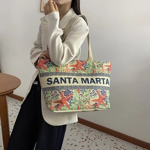 Detail of Santa Marta embroidered linen tote with red starfish and green seaweed patterns