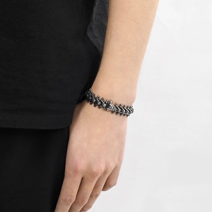 Detailed view of retro stainless steel spine bracelet with skull motif on male wrist