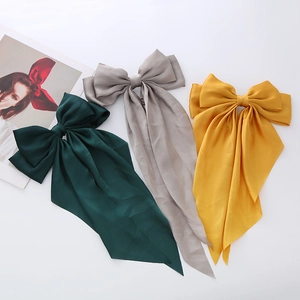 Three satin bow hair clips in green, grey, and yellow with elegant long streamers