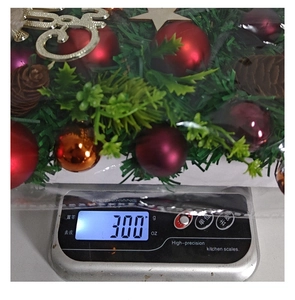 Christmas wreath weight measurement showing 300g on a digital scale for shipping info