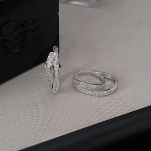 Detail of silver double-layered ear hoops with channel-set baguette-cut cubic zirconia