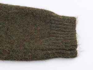 Macro shot of dark moss green mohair knit cardigan showing ribbed cuffs and plush texture