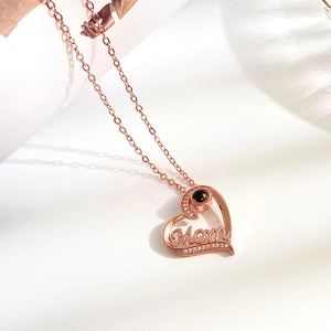 Rose gold MOM heart necklace with diamond accents and a central projection stone