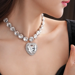 Close-up of luxury silver necklace with large crystal heart pendant worn by a model