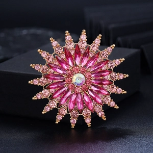 Macro detail of sunburst snowflake brooch with pink zircon and multifaceted center stone