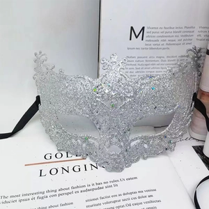 Detail of silver glitter masquerade mask with ornate filigree and crystal accents