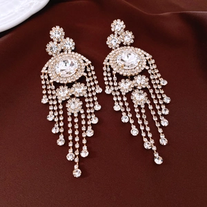 Macro shot of luxury vintage gold fringe earrings with sparkling rhinestone tassels