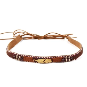 Detail of brown suede bohemian headband with golden feathers and wooden beads charms