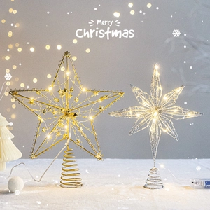 Golden and silver lighted Christmas tree star toppers with LED strings on snowy base