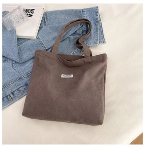 Detail of a brown canvas tote bag with a Fashion label in a casual lifestyle setting