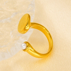 Gold plated geometric open ring with white pearl and hammered disc on silk background