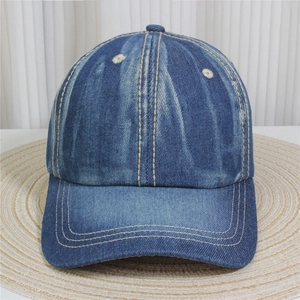 Detailed close-up of blue denim baseball cap featuring vintage wash and yellow stitching