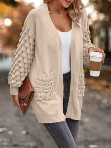 Beige V-neck feather knit cardigan with puff sleeves and pockets in outdoor autumn setting