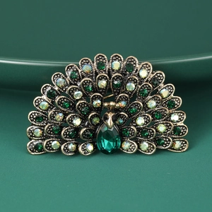 Macro shot of a peacock brooch with green crystals and antique bronze metal plating